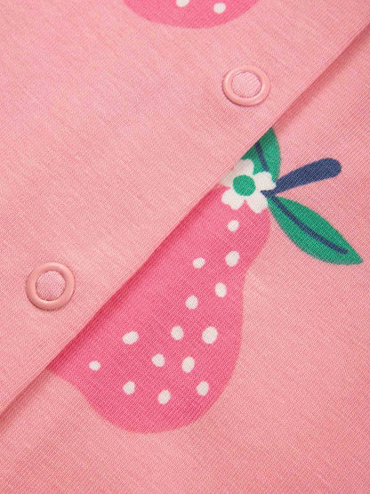 Detalle de botones y estampado de peras en pijama rosa orgánico para bebé