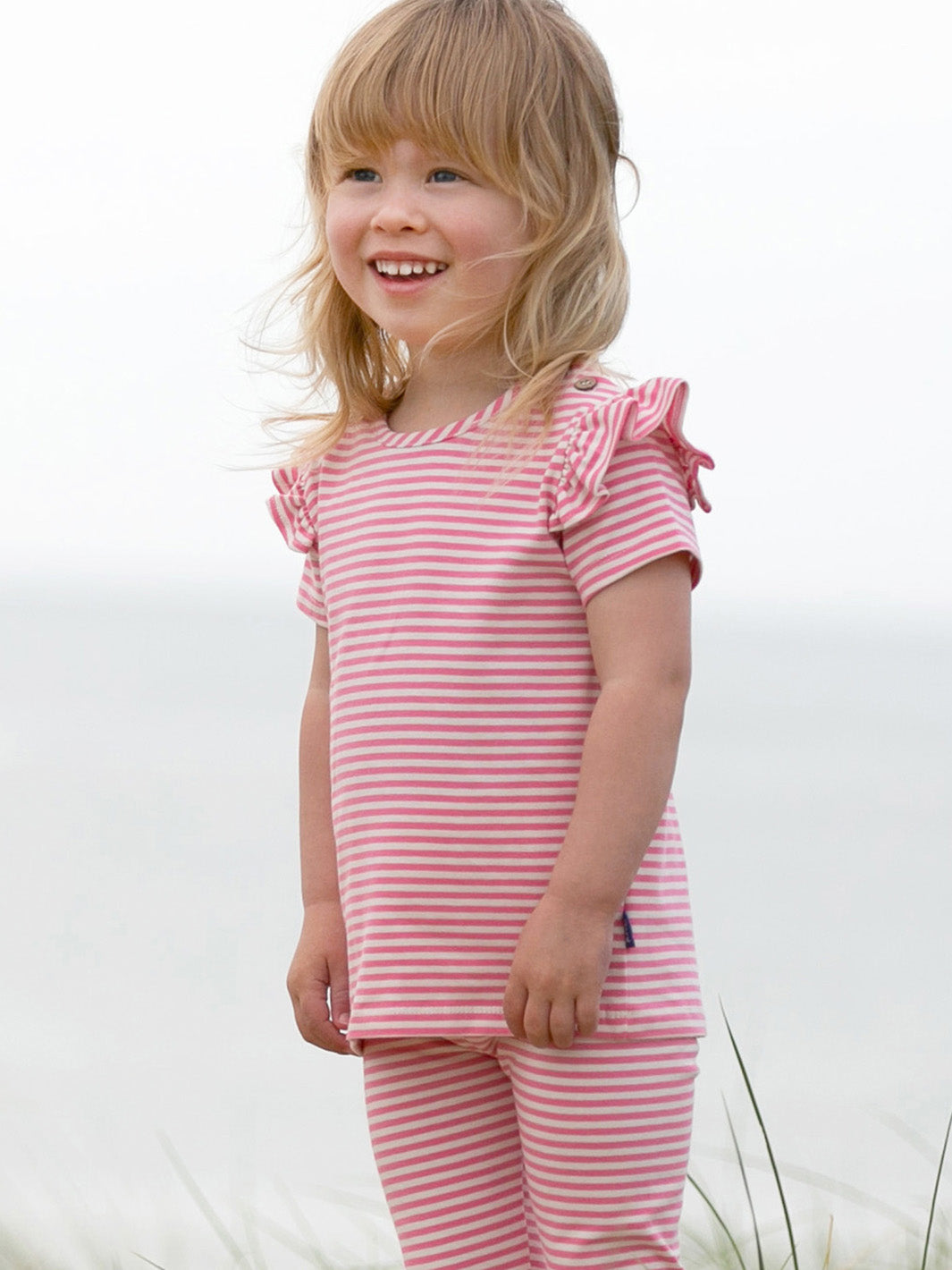 Niña usando la Polera con Alitas de algodón orgánico, combinada con shorts para un look fresco y cómodo