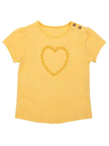 Polera Corazón Margaritas de algodón orgánico, en amarillo yema con inserto en forma de corazón de margaritas.