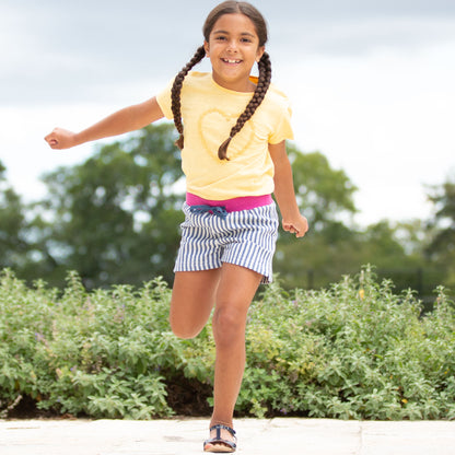 Niña disfrutando de la Polera Corazón Margaritas de algodón orgánico, perfecta para la comodidad y el movimiento
