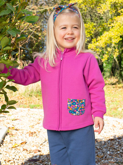 Niña usando el Polerón Detalles de Amor de algodón orgánico, combinado con pantalones para un look abrigador y encantador.