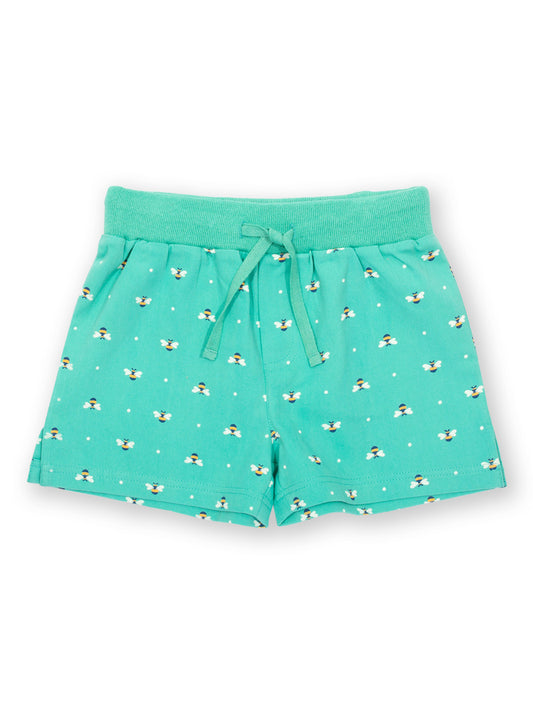 Short de algodón orgánico color verde menta con estampado de abejas reinas, cintura elástica y lazos ajustables. Diseño cómodo y fresco para niñas.
