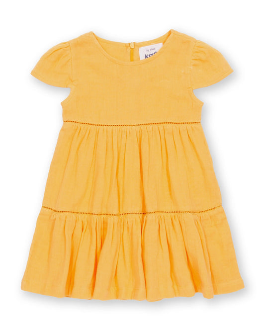 Vestido Atardecer de algodón orgánico, amarillo cálido con falda escalonada y mangas fruncidas.