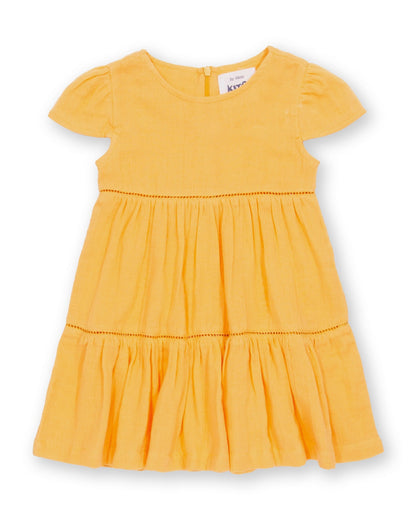 Vestido Atardecer de algodón orgánico, amarillo cálido con falda escalonada y mangas fruncidas.