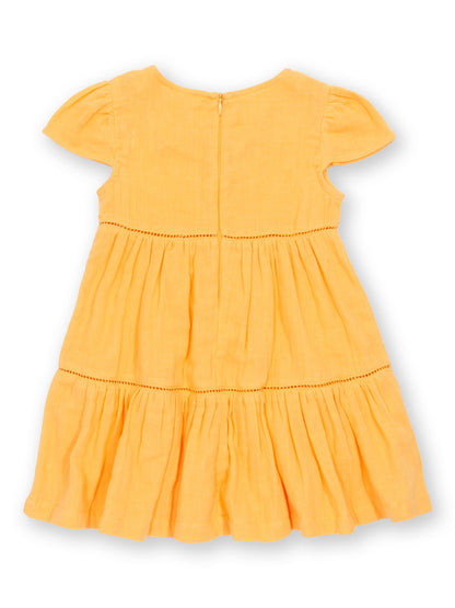 Vista trasera del Vestido Atardecer de algodón orgánico, con tela de muselina de doble capa y falda fluida.