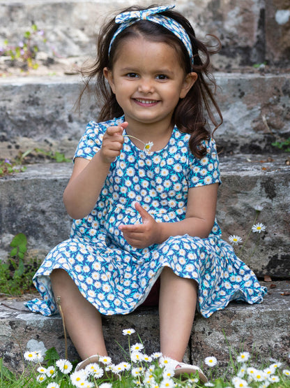 Niña disfrutando del Vestido Campo Floral de algodón orgánico, ideal para comodidad y movimiento.