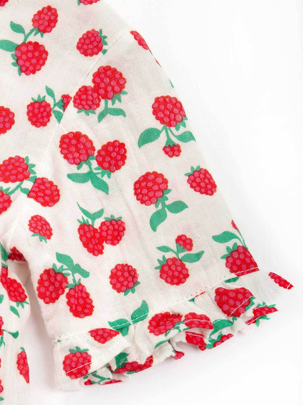 Vestido frambuesa de algodón orgánico para niña, mostrando detalle de vuelos en la manga
