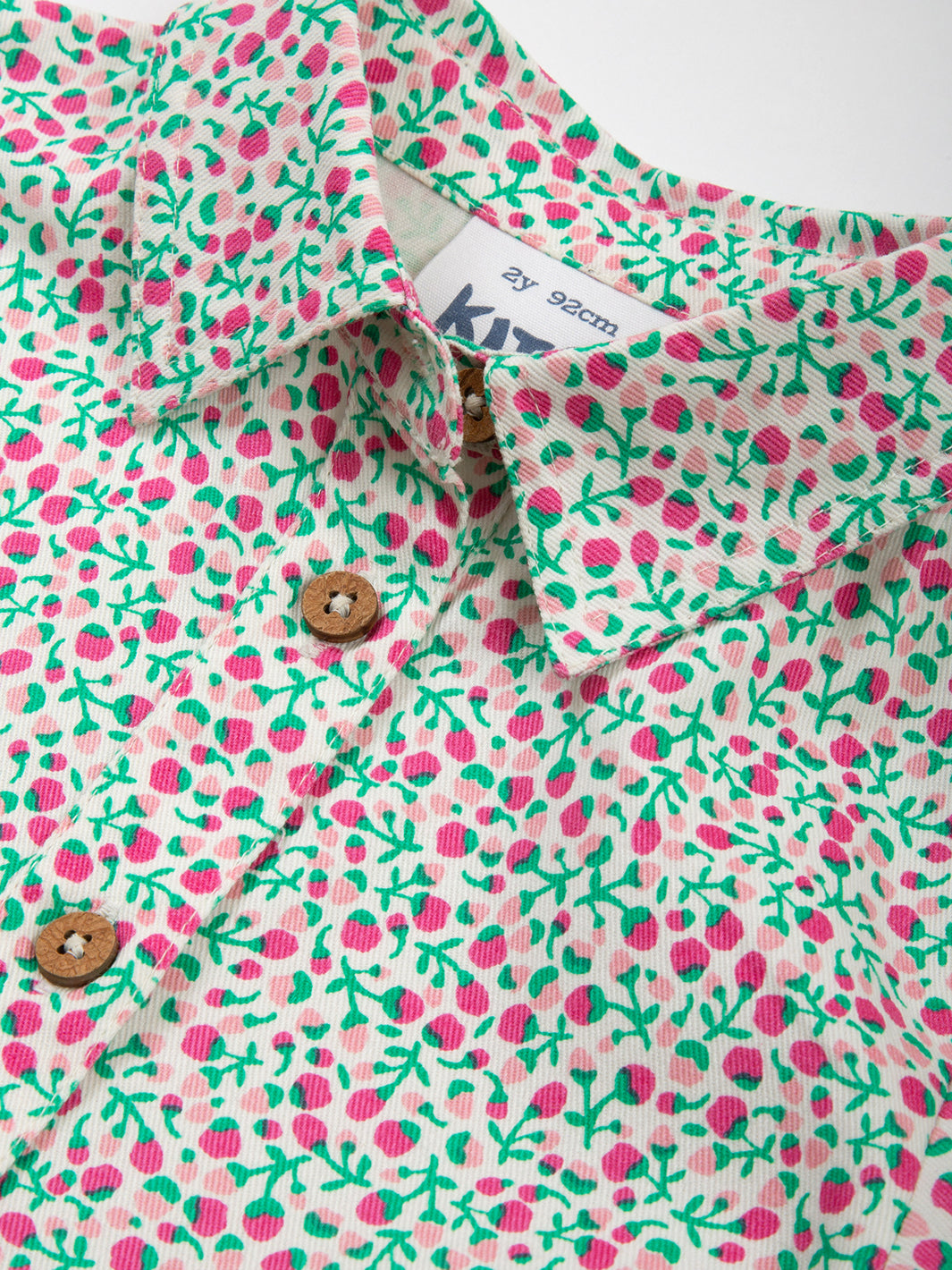 Detalle del cuello tipo camisa con soporte y botones de coco en el Vestido Pequeño Brote de algodón orgánico, diseño elegante y natural.