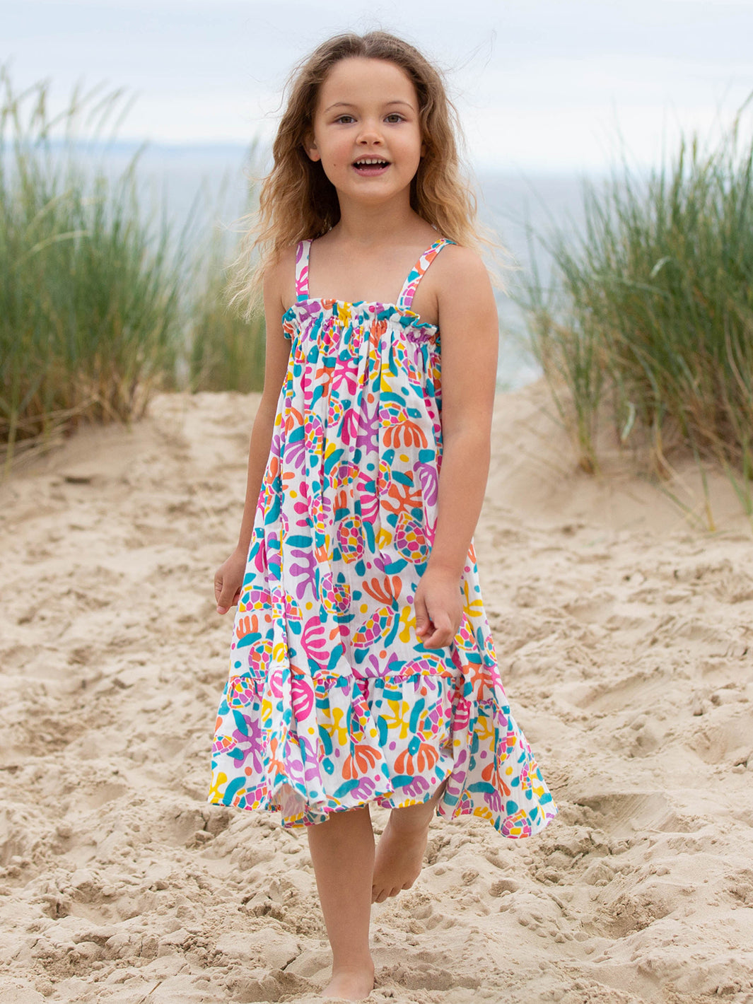 Niña paseando al aire libre con el Vestido Tortugas de Colores, disfrutando de su diseño ligero y fresco ideal para el verano.